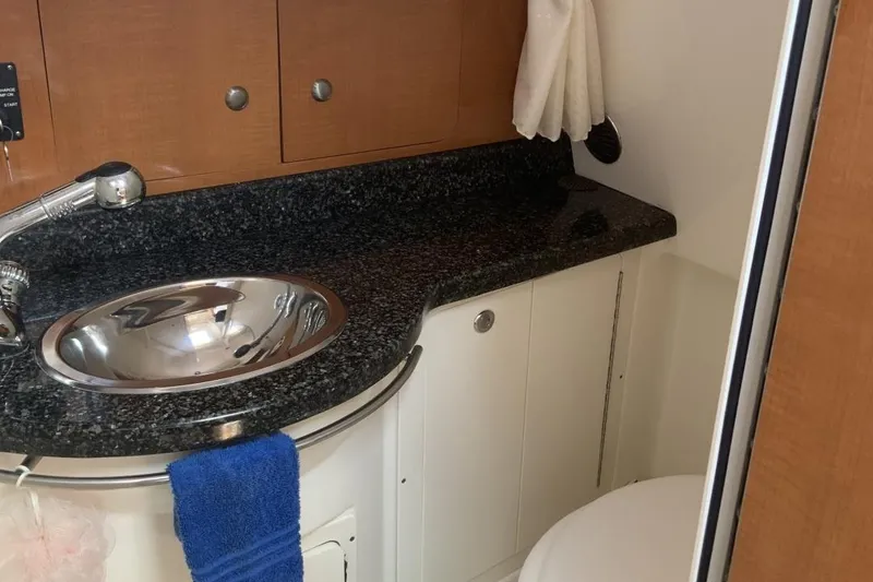Slide: The Image of 2007 Robalo R305 Walkaround bathroom with granite countertop and stainless steel sink. - 12