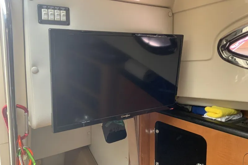 Slide: The Image of 2007 Robalo R305 Walkaround cabin interior with mounted TV and control panel. - 14