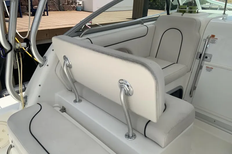 Slide: The Image of 2007 Robalo R305 Walkaround boat interior with white cushioned seating and stainless steel supports. - 5