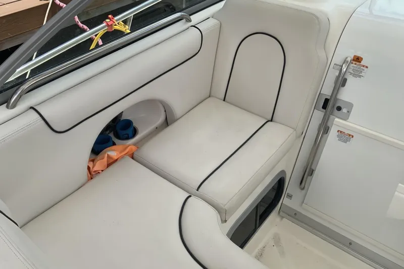 Slide: The Image of 2007 Robalo R305 Walkaround boat interior seating with white upholstery and storage compartment. - 6