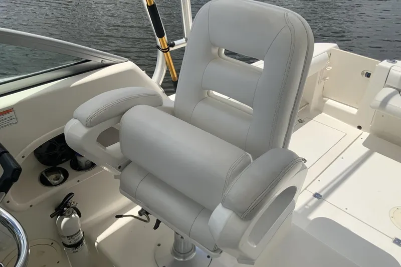 Slide: The Image of Captain's chair on 2007 Robalo R305 Walkaround boat, featuring white upholstery and armrests. - 7