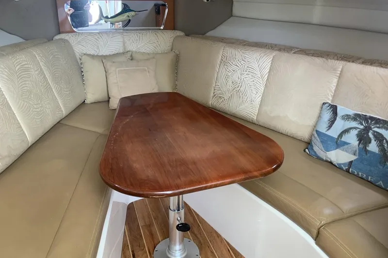 Slide: The Image of 2007 Robalo R305 Walkaround cabin interior with cushioned seating and wooden table. - 9