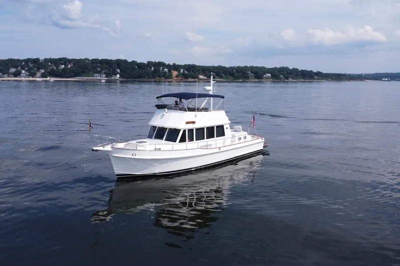 Slide: The Image of 2009 Grand Banks 47 Heritage CL yacht cruising on calm waters near a scenic shoreline. - 16
