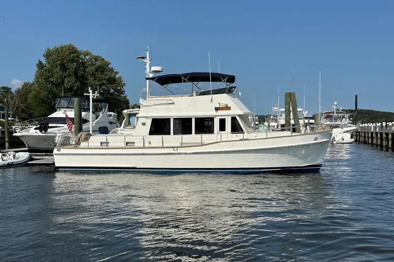 Slide: The Image of 2009 Grand Banks 47 Heritage CL yacht docked in a serene marina setting. - 17