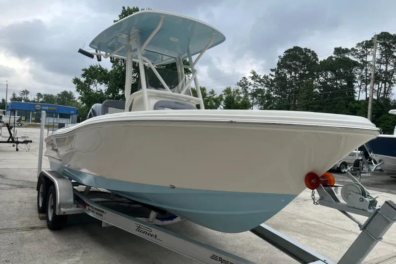 The Image of 2026 Pioneer 202 Islander boat on trailer, parked outdoors under cloudy sky. - 0