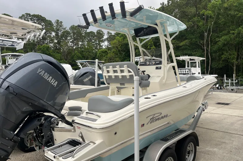 Slide: The Image of 2026 Pioneer 202 Islander boat with Yamaha engine, parked on a trailer in a marina. - 2