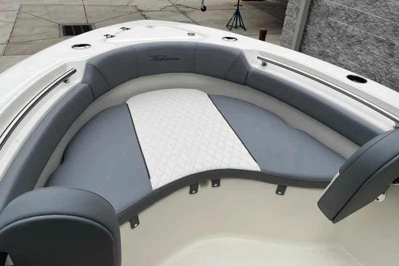 Slide: The Image of 2026 Pioneer 202 Islander boat interior with gray and white cushioned seating. - 21