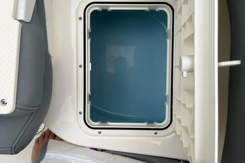 Slide: The Image of Open storage compartment on 2026 Pioneer 202 Islander boat, featuring a blue interior. - 29