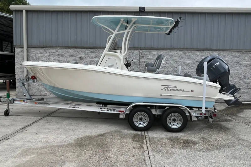 Slide: The Image of 2026 Pioneer 202 Islander boat on trailer, parked outdoors near a building. - 4