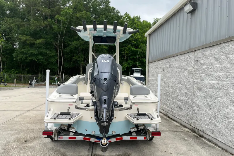Slide: The Image of 2026 Pioneer 202 Islander boat with powerful outboard motor, parked near a building. - 5
