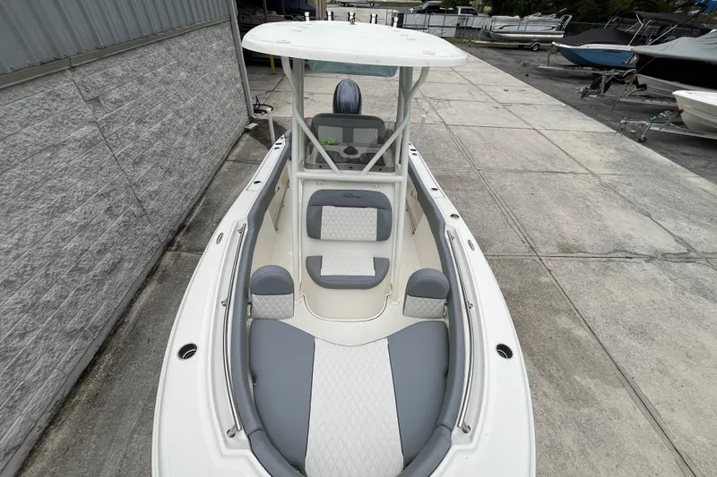 Slide: The Image of 2026 Pioneer 202 Islander boat with sleek design and comfortable seating, docked outdoors. - 6