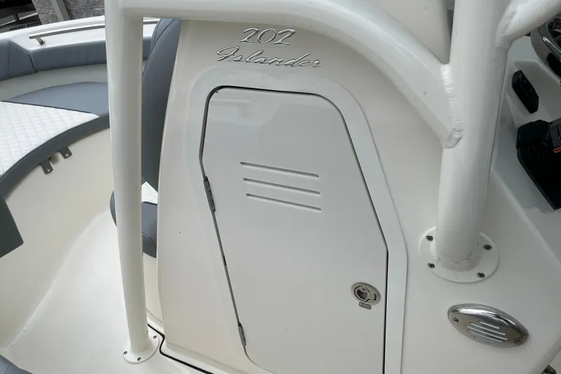 Slide: The Image of 2026 Pioneer 202 Islander boat interior, featuring sleek white design and storage compartment. - 9
