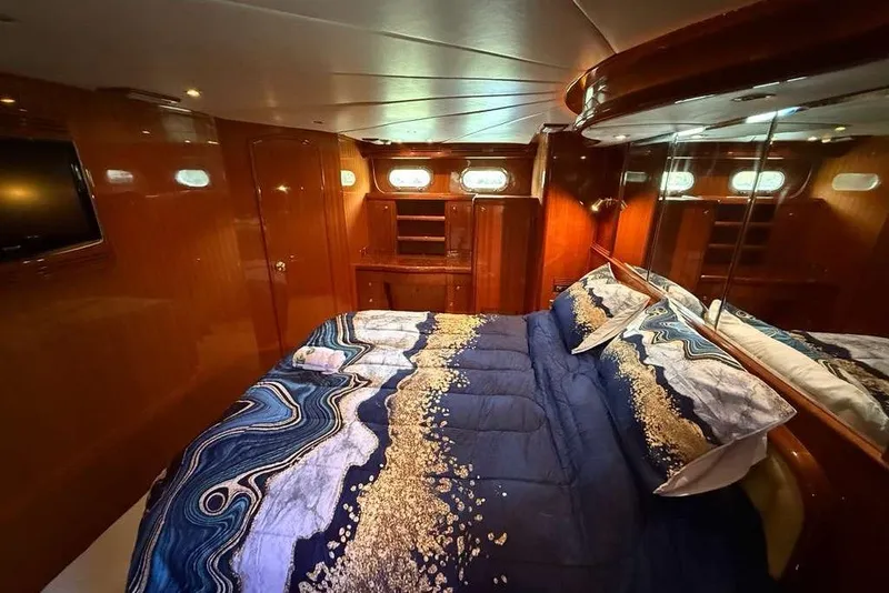 Slide: The Image of Luxurious bedroom in 2008 Hampton 60' Aft Cabin Motor Yacht with elegant bedding and wood paneling. - 20