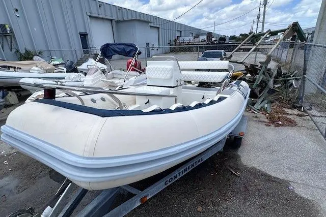 Slide: The Image of 2015 Novurania DL 460 inflatable boat on trailer, parked outdoors near industrial area. - 7