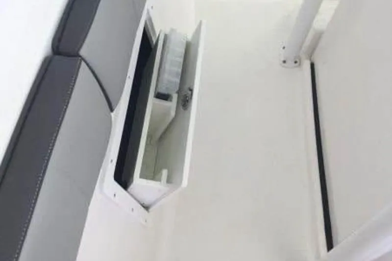 Slide: The Image of 2022 Aquasport 2500 Center Console interior storage compartment with gray seating. - 11