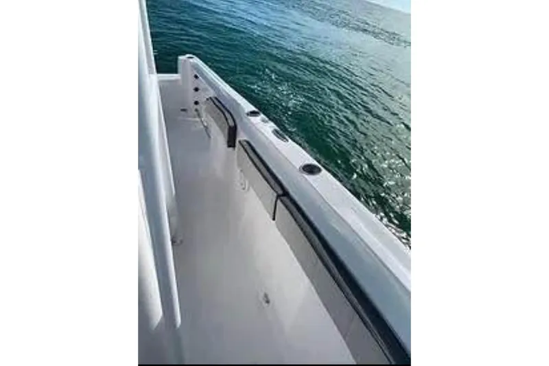 Slide: The Image of 2022 Aquasport 2500 Center Console boat side view on water. - 8