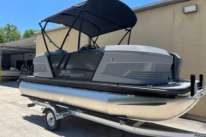 The Image of 2026 Starcraft GX 18 R pontoon boat on trailer, featuring sleek design and canopy. - 0