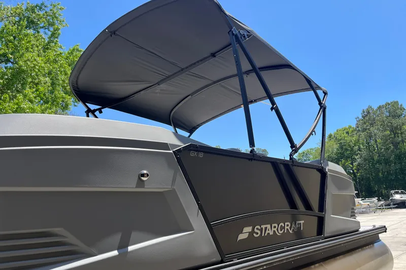 Slide: The Image of 2026 Starcraft GX 18 R boat with canopy, parked outdoors under clear blue sky. - 15
