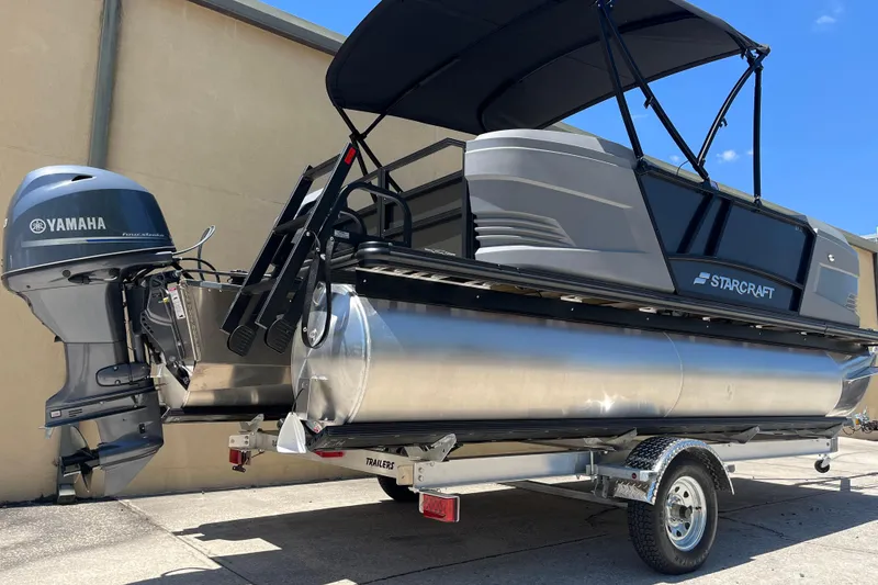 Slide: The Image of 2026 Starcraft GX 18 R pontoon boat with Yamaha engine on trailer, outdoor setting. - 2