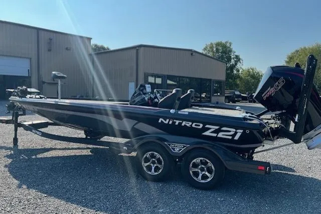 Slide: The Image of 2024 Nitro Z21 XL boat on trailer, parked outside a warehouse. - 7