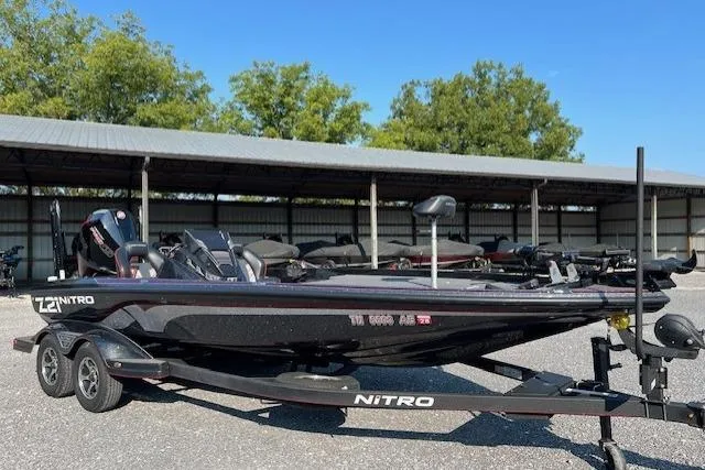 Slide: The Image of 2024 Nitro Z21 XL boat on trailer, parked outdoors under clear blue sky. - 9