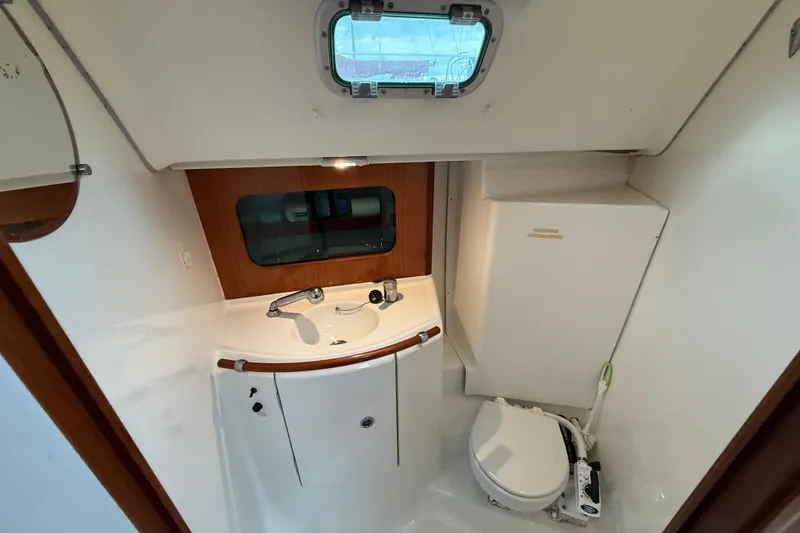 Slide: The Image of Interior of 2005 Beneteau 331 sailboat bathroom with sink, toilet, and porthole window. - 10