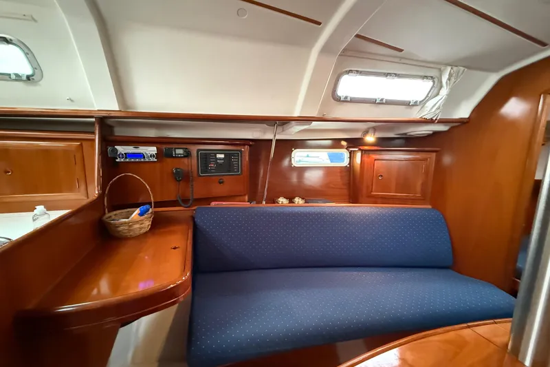Slide: The Image of Interior of 2005 Beneteau 331 sailboat with blue seating and wooden cabinetry. - 6
