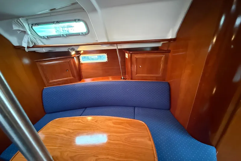 Slide: The Image of Interior of 2005 Beneteau 331 sailboat with blue seating and wooden cabinetry. - 9