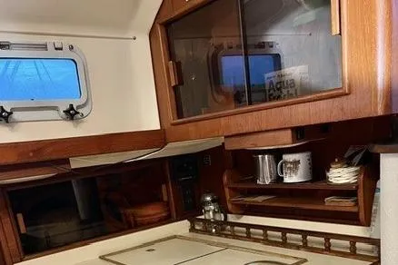 Slide: The Image of 1983 Nonsuch Cat Ketch interior with wooden cabinetry and nautical decor. - 10