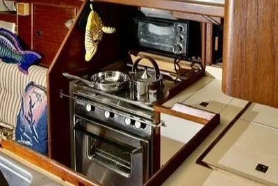 Slide: The Image of Compact kitchen area in a 1983 Nonsuch Cat Ketch sailboat with stove and oven. - 11