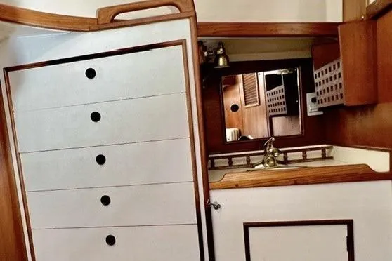 Slide: The Image of Interior of 1983 Nonsuch Cat Ketch sailboat with wooden cabinetry and compact sink area. - 13