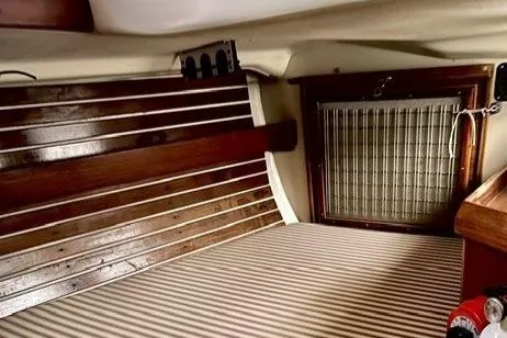 Slide: The Image of 1983 Nonsuch Cat Ketch interior with wood paneling and striped upholstery. - 20