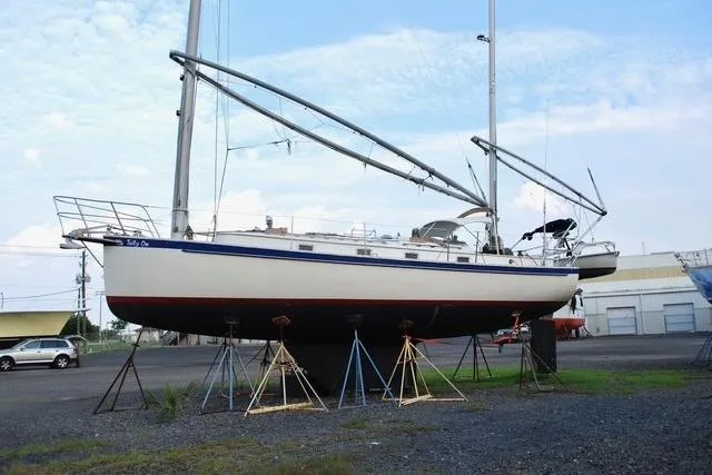 Slide: The Image of 1983 Nonsuch Cat Ketch sailboat on stands in a boatyard, clear sky background. - 22