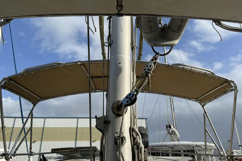 Slide: The Image of 1983 Nonsuch Cat Ketch sailboat mast and rigging under a cloudy sky. - 26