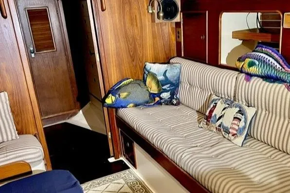Slide: The Image of Interior of 1983 Nonsuch Cat Ketch with striped seating and colorful fish-themed pillows. - 7