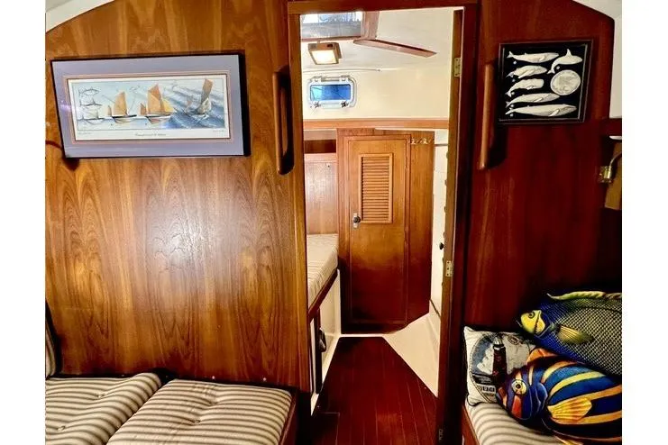 Slide: The Image of Interior of 1983 Nonsuch Cat Ketch sailboat with wood paneling and nautical decor. - 8