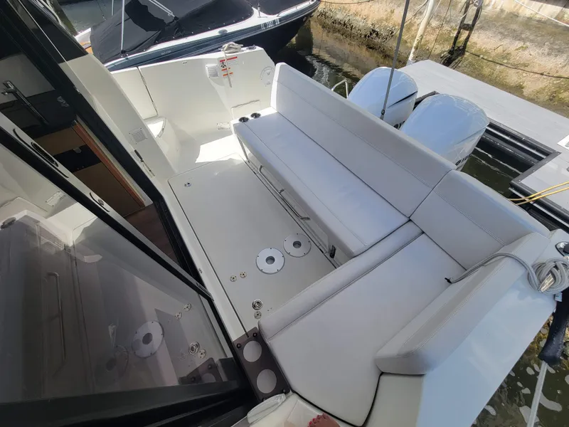 Slide: The Image of 2020 Jeanneau NC1095 boat deck with seating and twin outboard engines. - 12