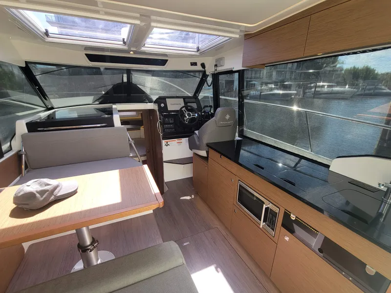 Slide: The Image of Interior of 2020 Jeanneau NC1095 boat with modern kitchen and seating area. - 23