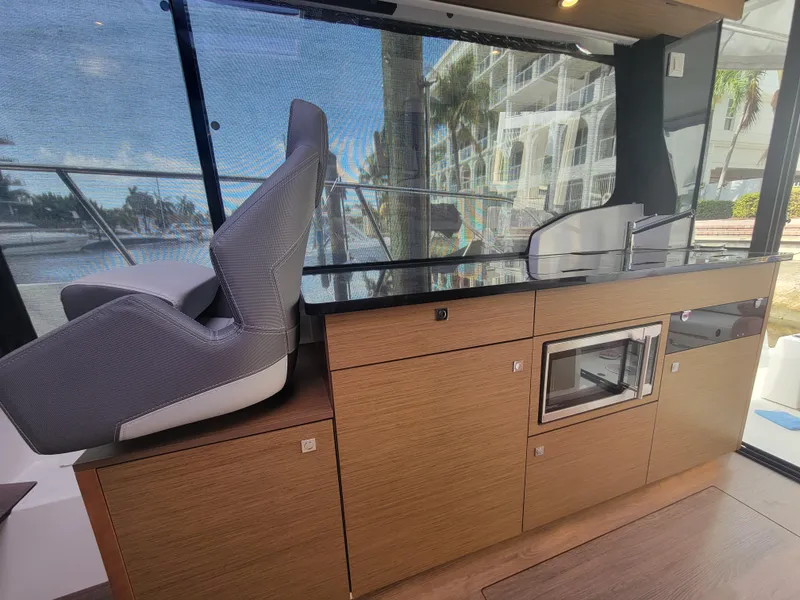 Slide: The Image of Interior of 2020 Jeanneau NC1095 boat with modern kitchen and seating area. - 25
