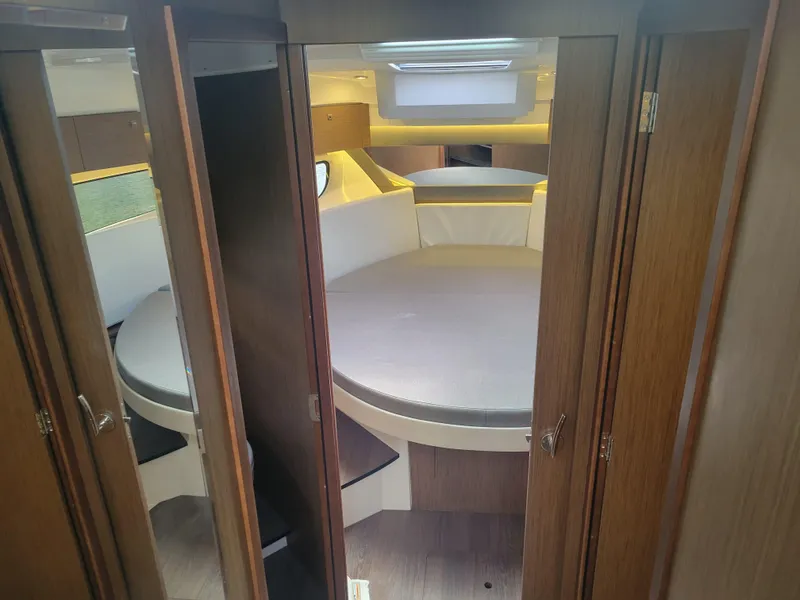 Slide: The Image of Interior cabin of 2020 Jeanneau NC1095 boat with round bed and wooden finish. - 30