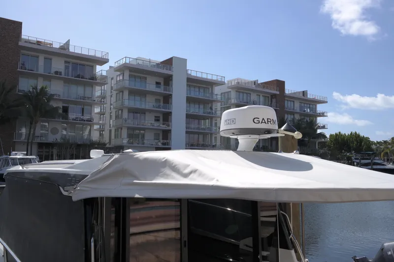 Slide: The Image of Jeanneau NC1095 boat docked near modern apartments, 2020 model. - 5
