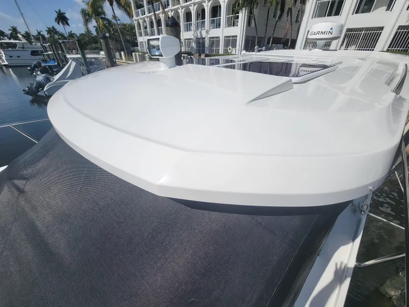 Slide: The Image of 2020 Jeanneau NC1095 boat roof with sleek design, docked near palm trees and buildings. - 8