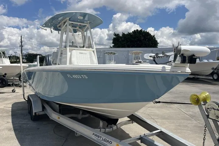 The Image of 2023 Pathfinder 2400 TRS boat on trailer under cloudy sky at marina. - 0