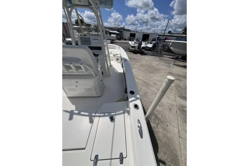 Slide: The Image of 2023 Pathfinder 2400 TRS boat docked, showcasing deck and seating area under clear skies. - 11