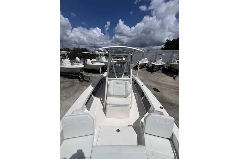 Slide: The Image of 2023 Pathfinder 2400 TRS boat with sleek design, docked under a partly cloudy sky. - 17
