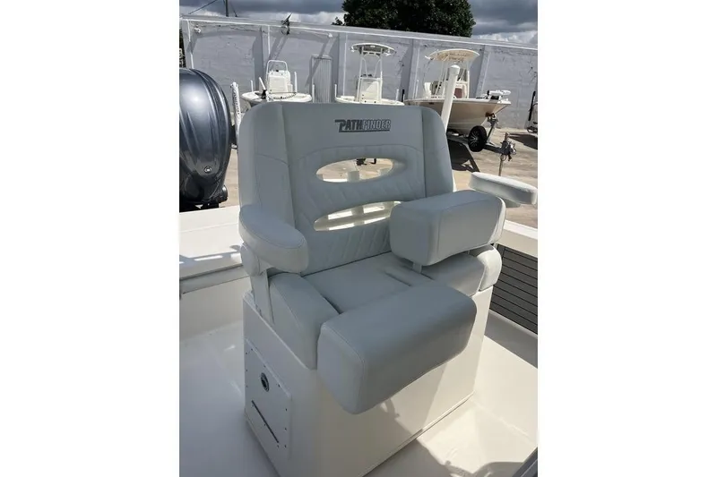 Slide: The Image of 2023 Pathfinder 2400 TRS boat seat with armrests, outdoor setting. - 21
