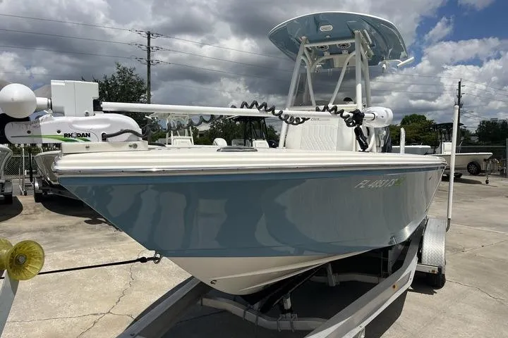 Slide: The Image of 2023 Pathfinder 2400 TRS boat on trailer, blue hull, parked outdoors under cloudy sky. - 3