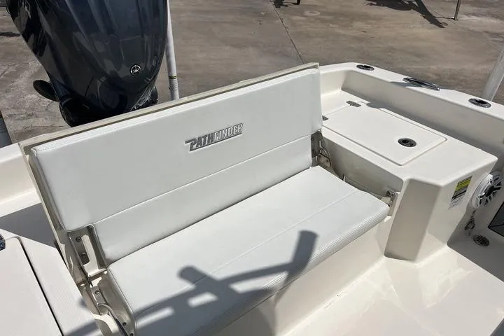 Slide: The Image of 2023 Pathfinder 2400 TRS boat seating area with white upholstery and storage compartment. - 6