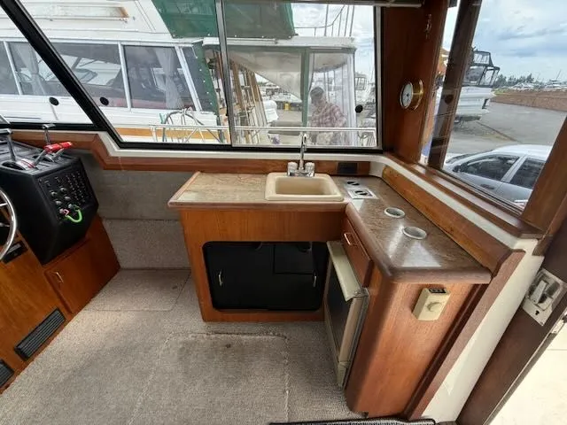 Slide: The Image of Interior of 1990 Bayliner 3888 Motoryacht featuring kitchen and helm area. - 14