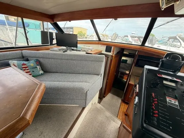 Slide: The Image of Interior of 1990 Bayliner 3888 Motoryacht with gray sofa and helm console. - 16